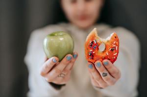 A person chooses between an apple or donut