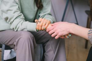 Two people hold hands to show comfort
