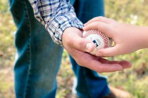 One person hands a baseball to another