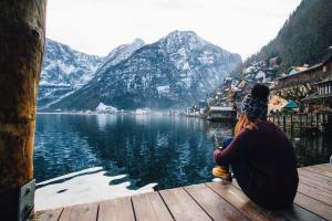 Woman looks at lake and mountain