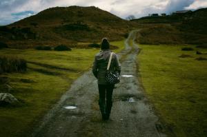 A woman walks on a path toward a village