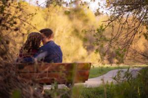 Man and woman close together on park bench