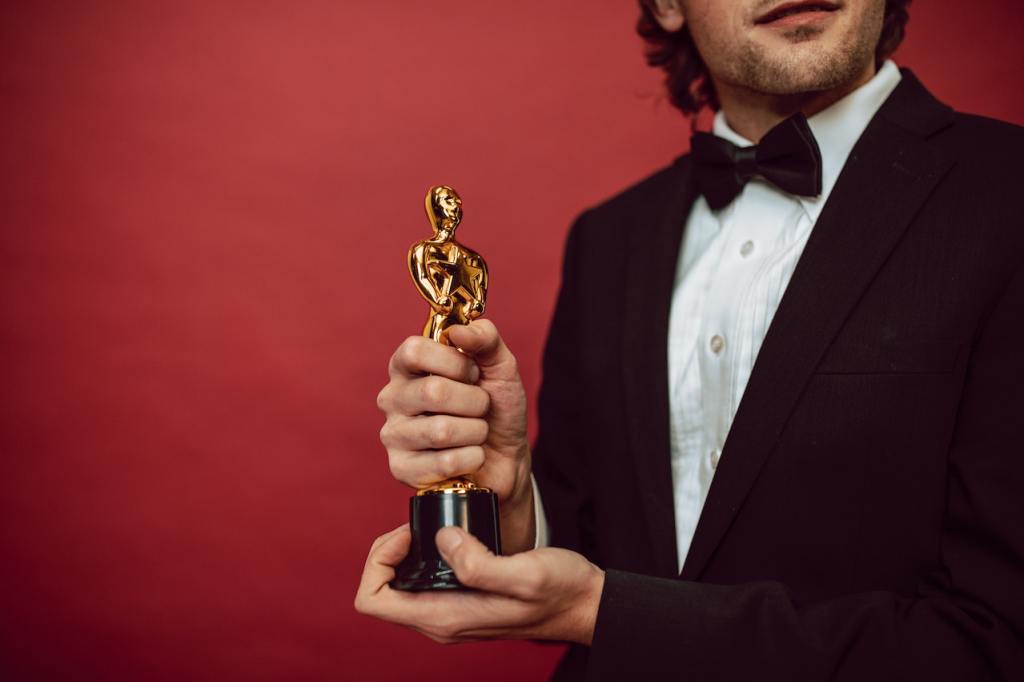 Man in tux holds award